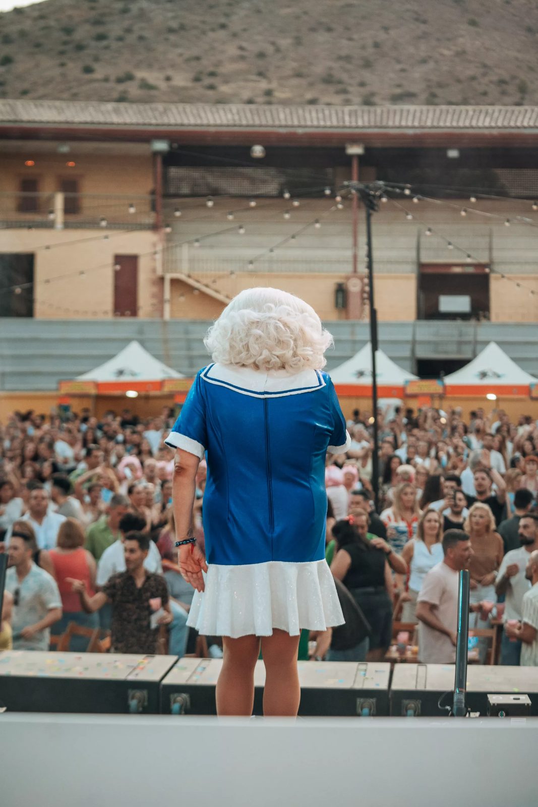Artista drag con megáfono animando el tardeo.
