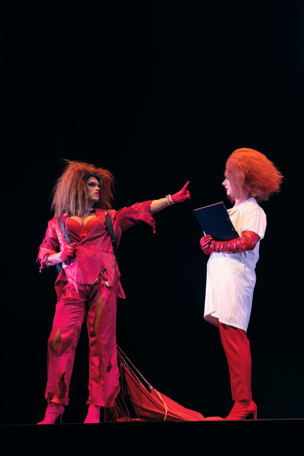 Las Pilardos en pleno show, escena iluminada en rojo.